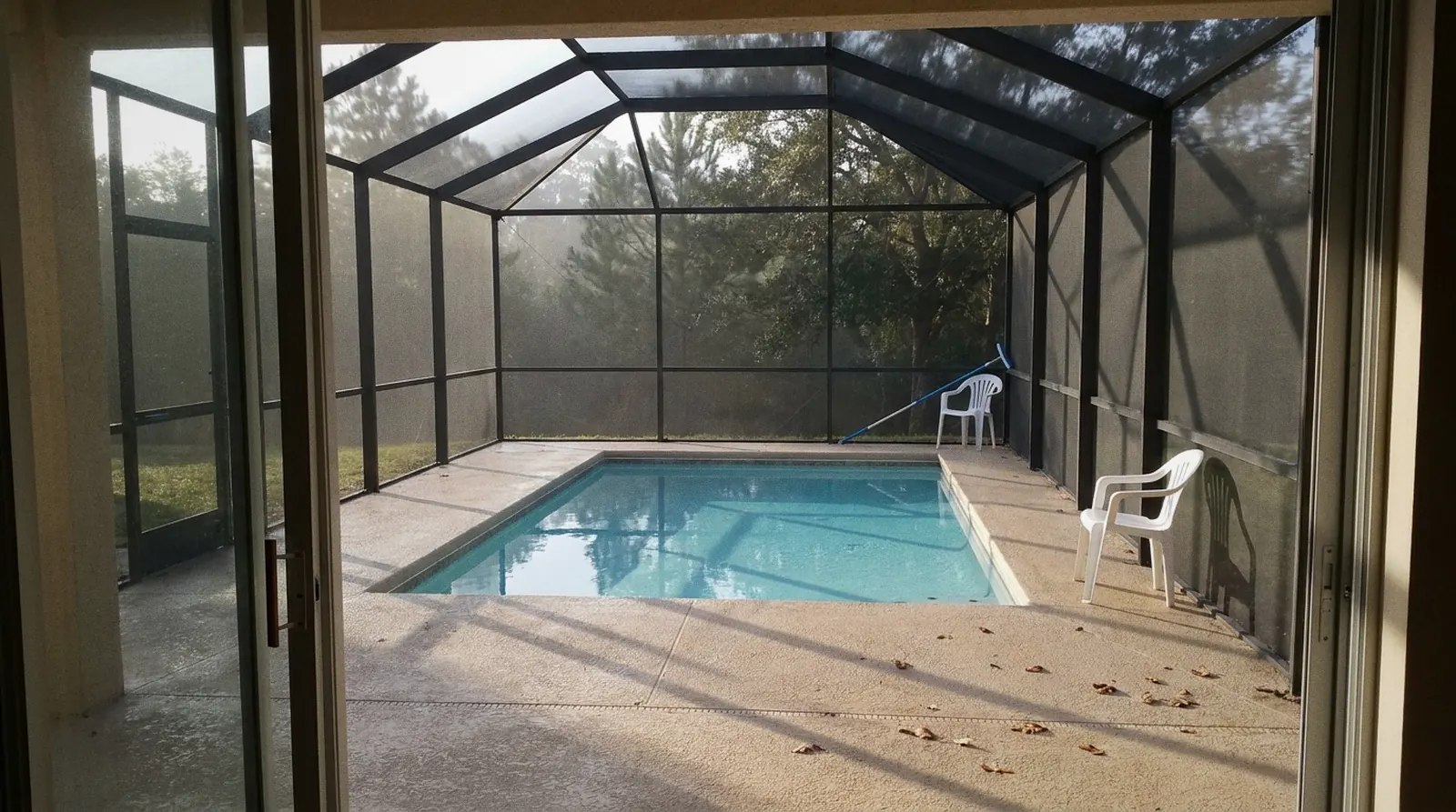 Screened in-ground pool at a Deltona, FL home in early morning light